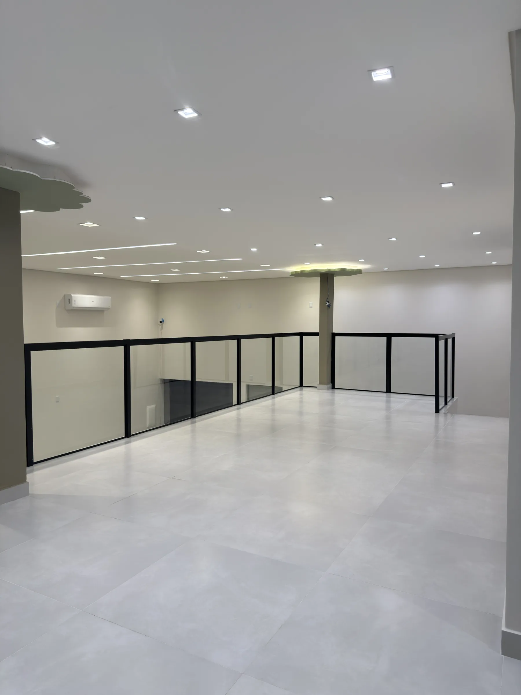 Mezanino da Dondoka Recepções, piso superior amplo com guarda-corpo de vidro e metal