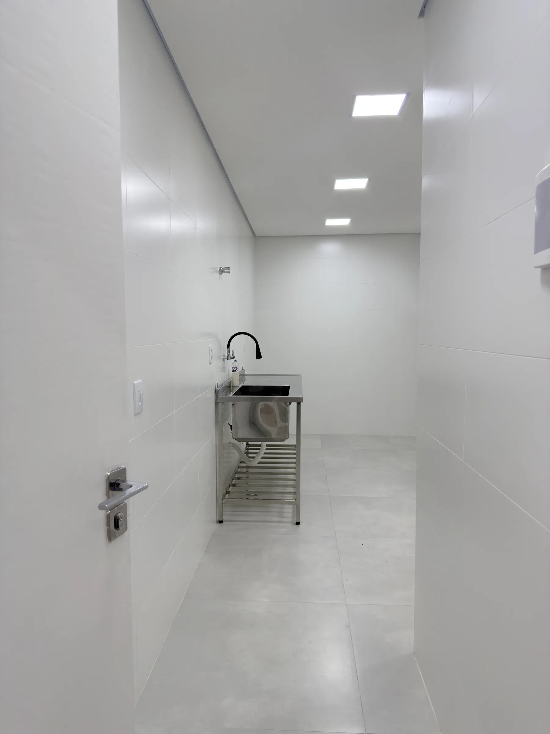Área de apoio da cozinha da Dondoka Recepções, com cuba e bancada em inox