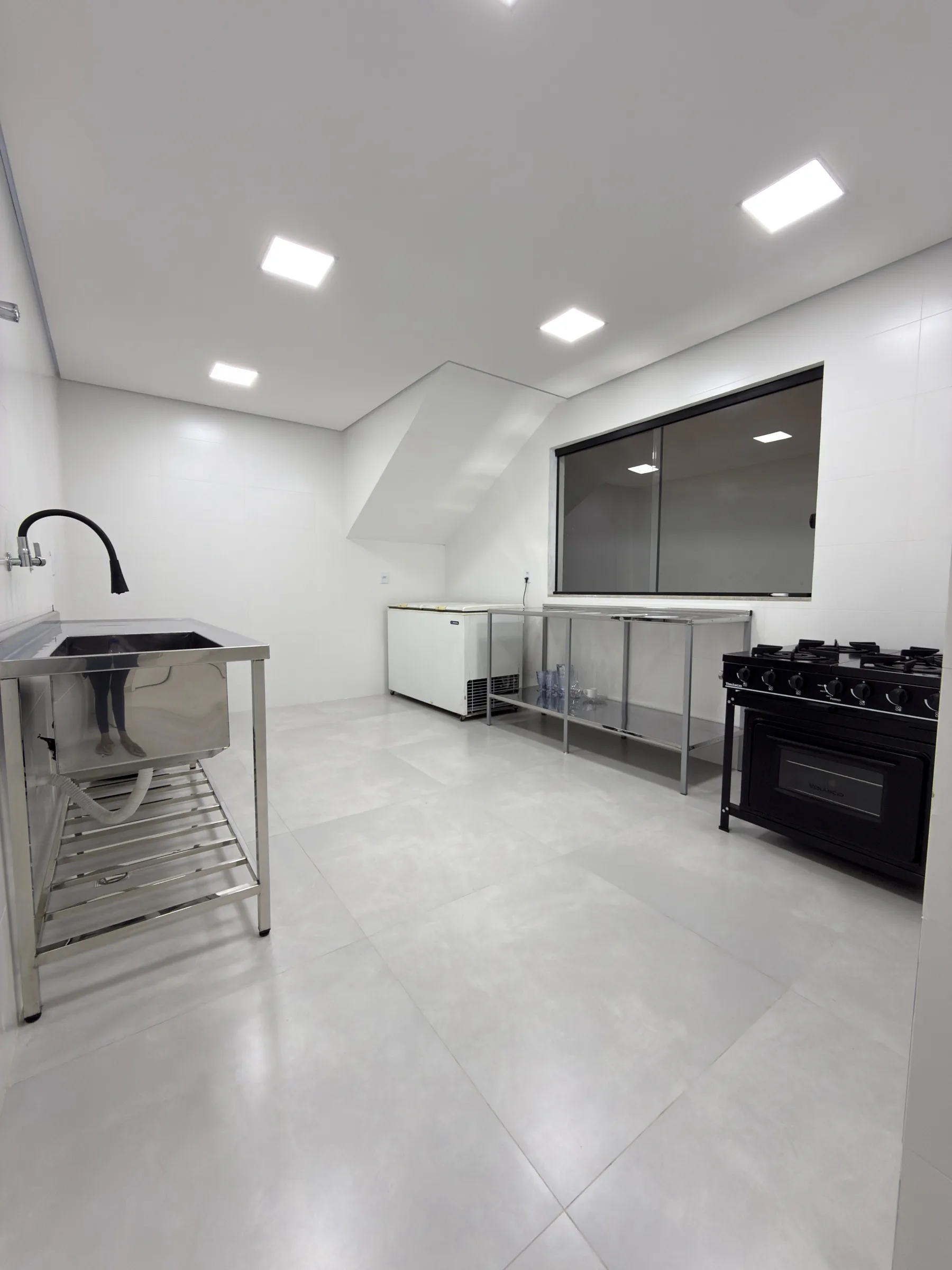 Cozinha industrial da Dondoka Recepções com fogão de 6 bocas e bancadas em inox